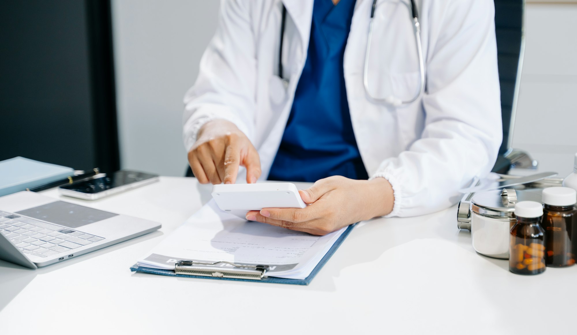 Healthcare costs and fees concept.Hand of smart doctor used a calculator